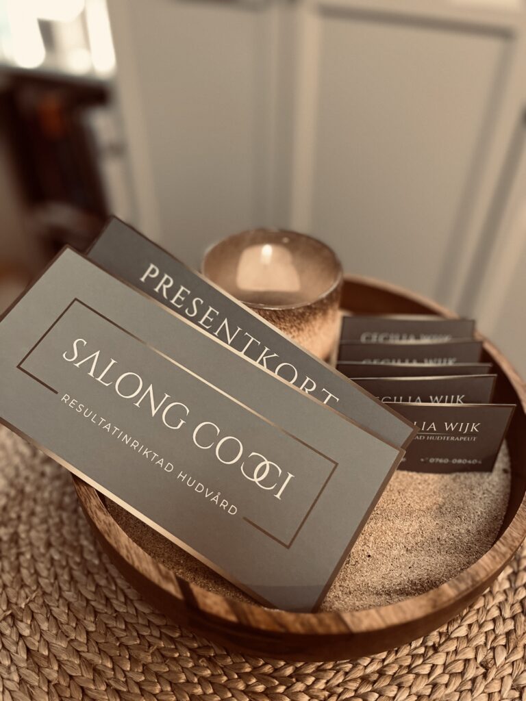 Salong Coccis presentkort på ett fat med ljus och choklad